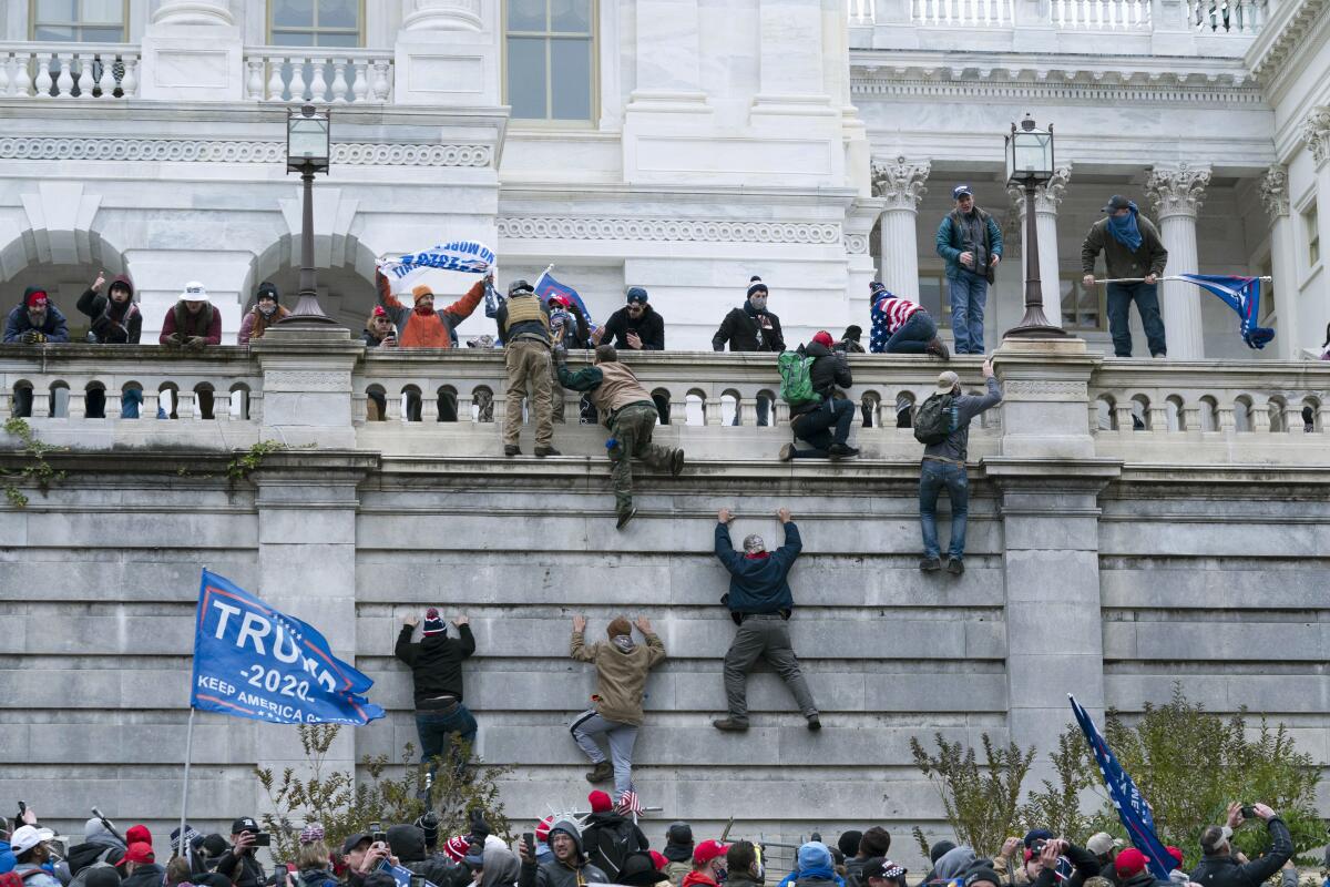 Supporters of President Trump climb the west wall of the U.S. Capitol on Wednesday in Washington.